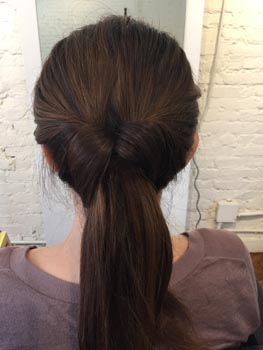 結び目の上に分け目を作り、そこに毛束を入れる。