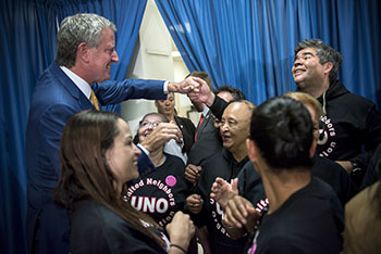 署名し支持団体のスタッフらと握手を交わす市長(左)=8月30日、マンハッタン区(photo: Ed Reed/Mayoral Photography Office)