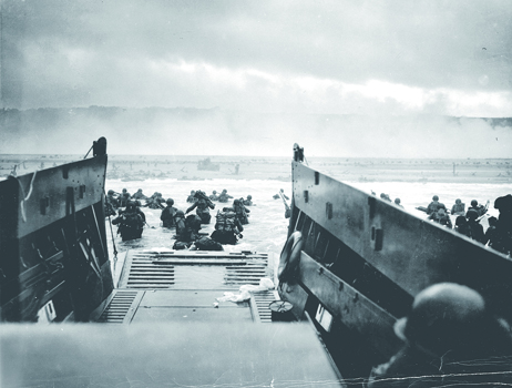 「史上最大の上陸作戦」と呼ばれるノルマンディー上陸は1944年6月6日未明に開始。写真はオマハビーチに上陸する米第1歩兵師団第16歩兵連隊E中隊。(Into the Jaws of Death：ロバート・F・サージェント撮影）