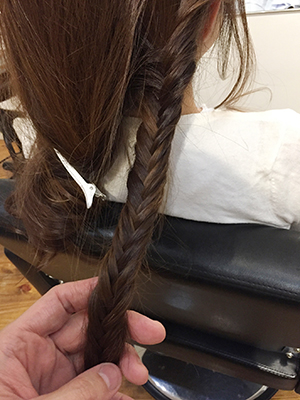 ３分の１ほどの毛束を取り フィッシュボーン編みにする。 毛先まで編み込んだら ゴムで留める。