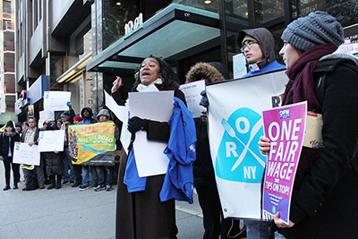 時給の均等を訴えるキャサリン・バーネットさん(中央)と参加者ら=25日午前、マンハッタン区のニューヨーク州レストラン協会ビル前で撮影(photo: Yuriko Anzai / 本紙)