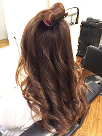 トップの毛を巻いてボリュームを出します。後ろの毛は縦巻きに。