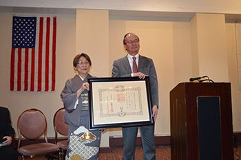 勲記および勲章を受けたハタさん（左）と髙橋大使（photo: 日本総領事館）