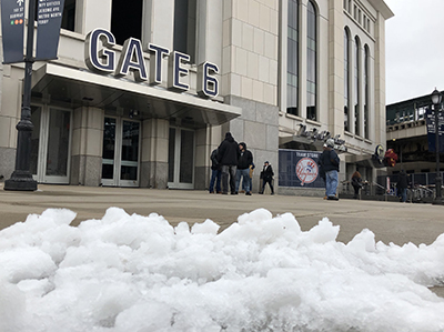 雪で試合が延期となったヤンキースタジアムの正面ゲート。雪が止んだ２日午後も、道路脇には雪が残っていた （photo: Yuriko Anzai / 本紙）