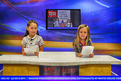 ニュースキャスターになりきるリリアナさん（左）（photo: Jen Bruno）