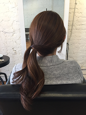 サイドに残した毛束を、先ほど作った結び目の上でとめます