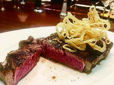 現在もダウンタウンのデルモニコスで食べられるオリジナルのデルモニコスステーキ。焼き方もハーブ入りバターで仕上げる調理法も150年間変わらないが、部位はプライムビーフの骨なしリブアイにアップグレードした